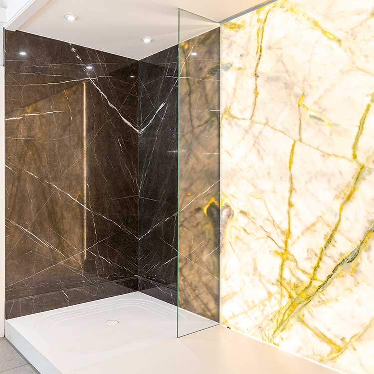 Displays of book-matched and back-lit stone wall cladding inside the showroom at LBS Stone in Storrington