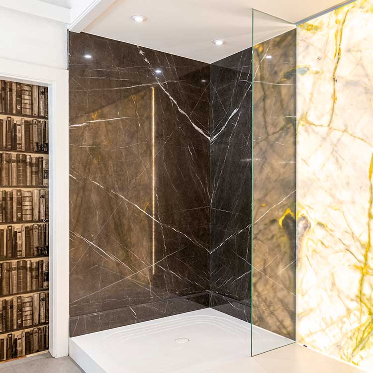 Wetroom shower with mocha bookmatched stone wall cladding on display in the showroom at LBS Stone in Storrington