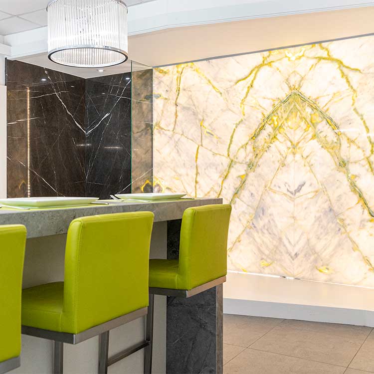 Large slabs of back-lit book-matched marble used to create a stunning stone wall cladding feature in the LBS Stone showroom in Storrington, West Sussex