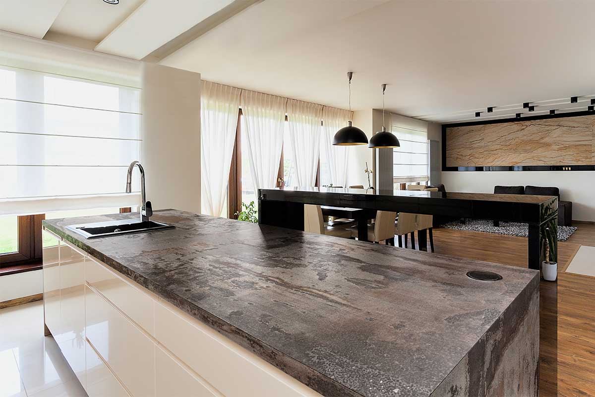 Large kitchen island featuring a rusty metallic Dekton Trilium sintered stone worktop and cladding